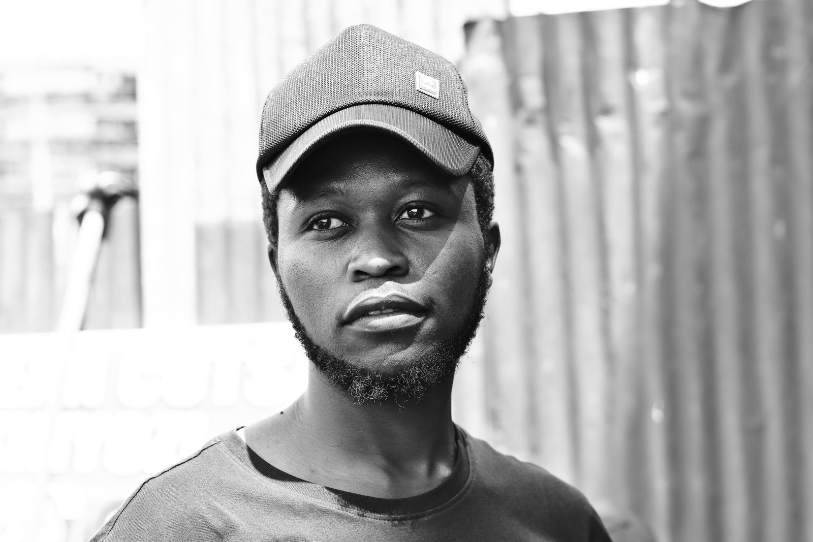 Striking black and white portrait of a young man wearing a cap in Nairobi.